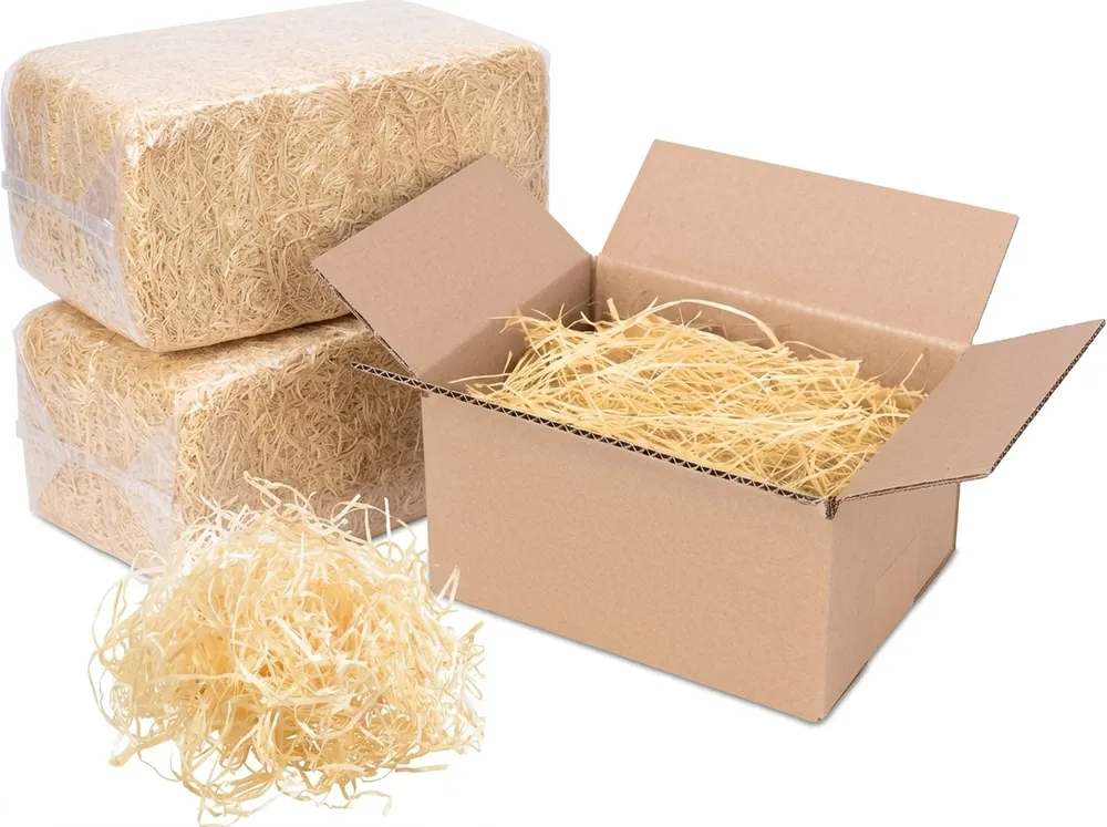 Wood wool as void fill in a shipping box, next to two 10 kg bales and loose material